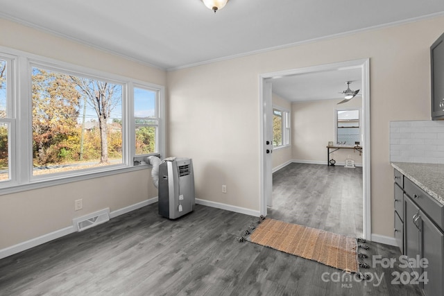 interior space with dark hardwood / wood-style floors, ceiling fan, and crown molding