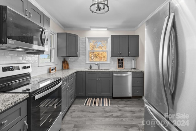 kitchen featuring light stone countertops, appliances with stainless steel finishes, gray cabinetry, sink, and dark hardwood / wood-style floors