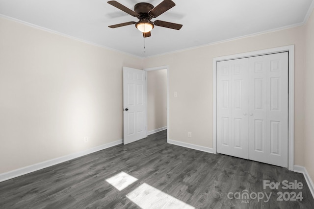 unfurnished bedroom featuring a closet, dark hardwood / wood-style floors, ceiling fan, and crown molding