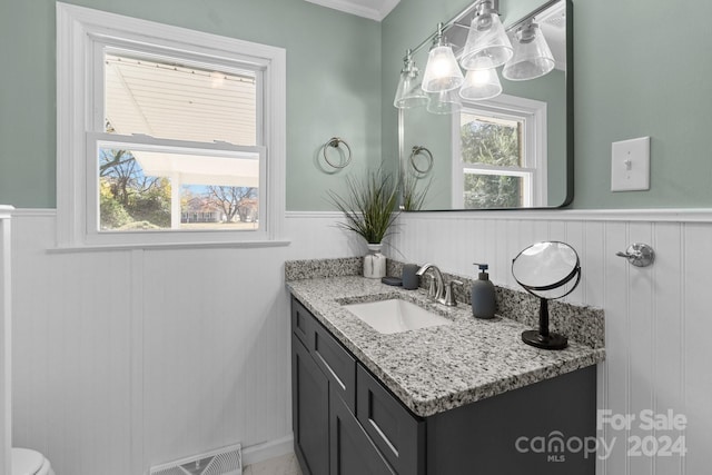 bathroom featuring vanity, a wealth of natural light, and ornamental molding