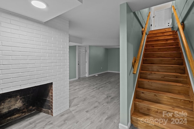 stairway featuring a fireplace and hardwood / wood-style floors