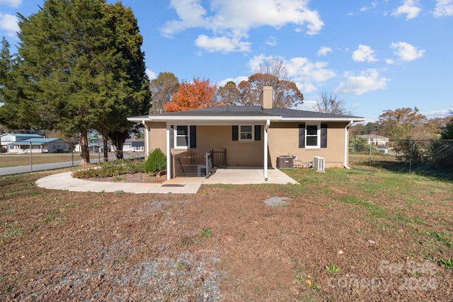 rear view of house featuring a lawn, a patio, and central AC