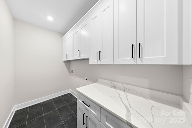 laundry room with cabinets, hookup for an electric dryer, hookup for a washing machine, and dark tile patterned floors