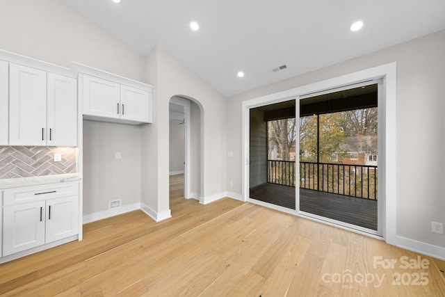 interior space featuring lofted ceiling and light wood-type flooring