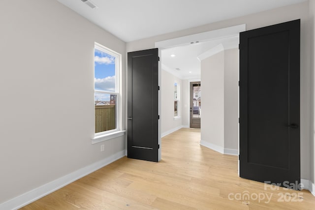 empty room featuring visible vents, baseboards, crown molding, light wood-type flooring, and recessed lighting