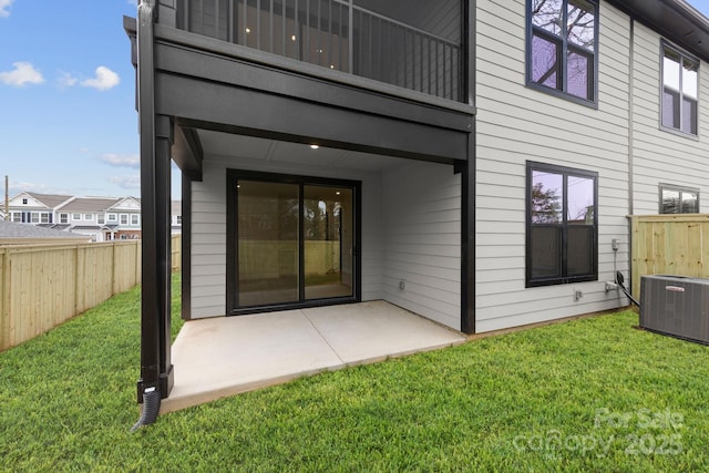 rear view of house featuring cooling unit, a patio area, fence, and a lawn