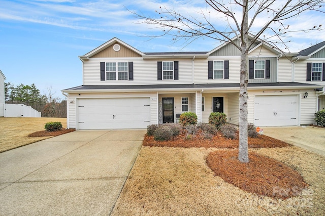 view of front facade featuring driveway, an attached garage, and fence