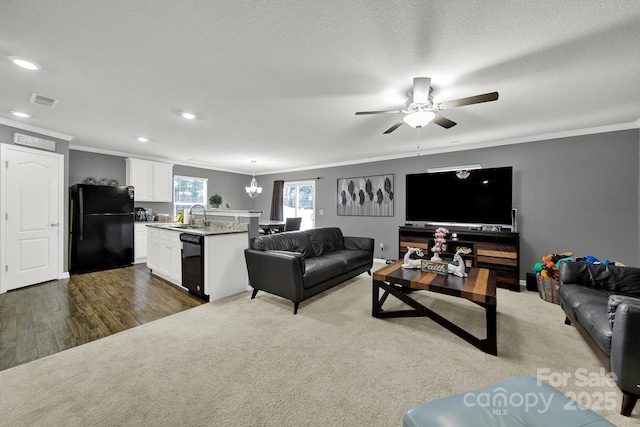 living room with dark wood finished floors, a textured ceiling, visible vents, and ornamental molding