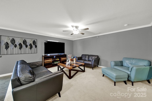 living room featuring a ceiling fan, visible vents, baseboards, ornamental molding, and light carpet