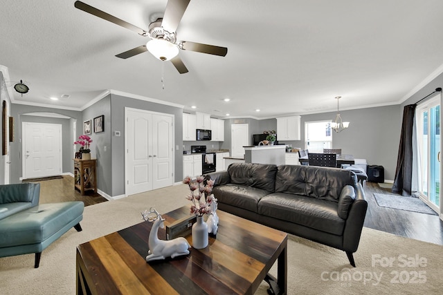 living room with baseboards, ornamental molding, recessed lighting, wood finished floors, and arched walkways