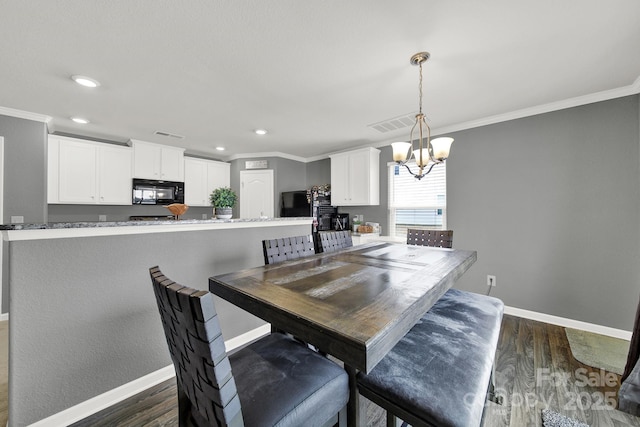 dining area with dark wood finished floors, an inviting chandelier, baseboards, and ornamental molding