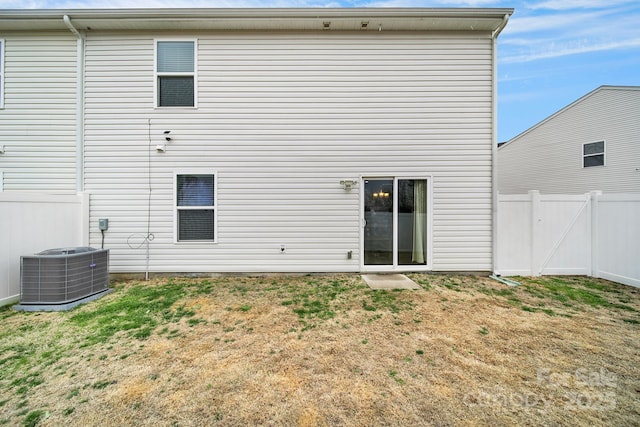 back of house with a lawn, central AC unit, and fence