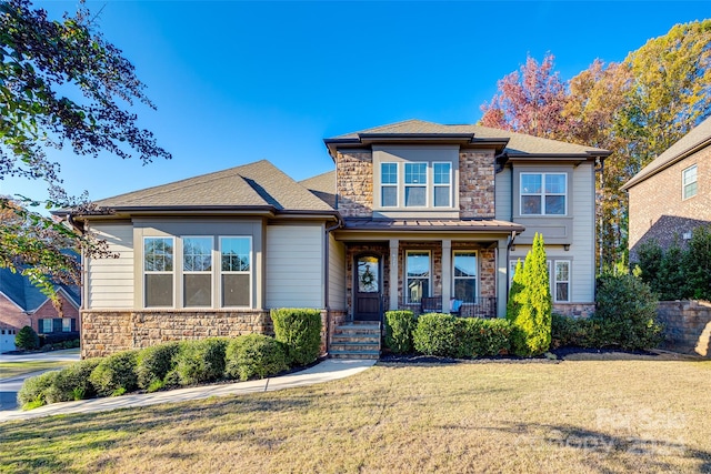 view of front of house with covered porch and a front lawn