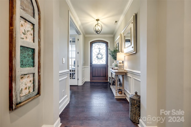 foyer featuring a chandelier, ornamental molding, and dark wood-type flooring