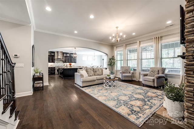 living room with crown molding, dark hardwood / wood-style floors, and an inviting chandelier