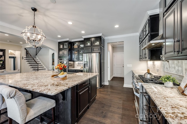 kitchen featuring decorative backsplash, stainless steel appliances, pendant lighting, a center island, and dark hardwood / wood-style floors