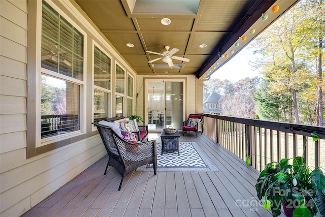 wooden deck with outdoor lounge area and ceiling fan