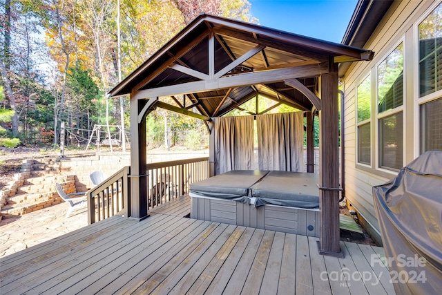 wooden terrace featuring a gazebo and a covered hot tub