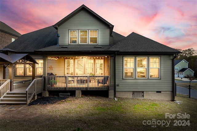 back house at dusk featuring a deck