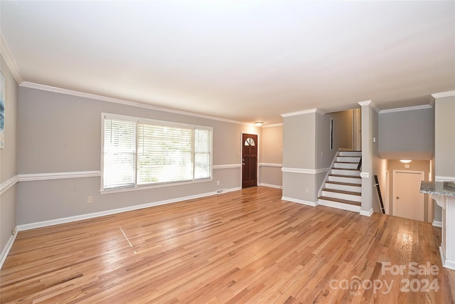 unfurnished living room with ornamental molding and light wood-type flooring