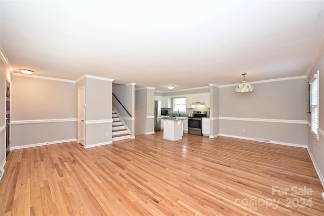 unfurnished living room with a healthy amount of sunlight, ornamental molding, and light hardwood / wood-style flooring