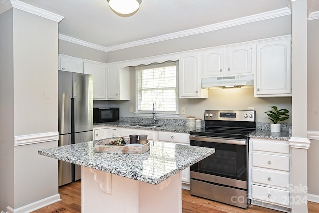 kitchen featuring a center island, sink, light stone countertops, light hardwood / wood-style floors, and stainless steel appliances