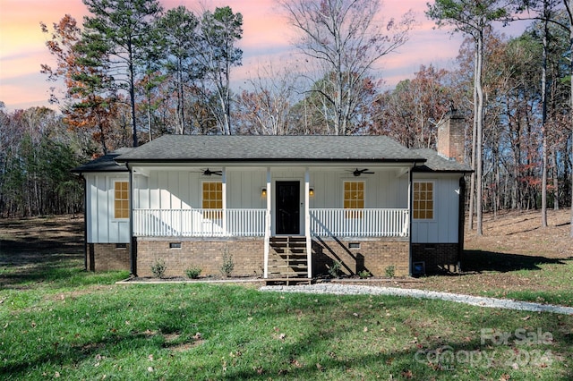 view of front facade with ceiling fan, a yard, and covered porch