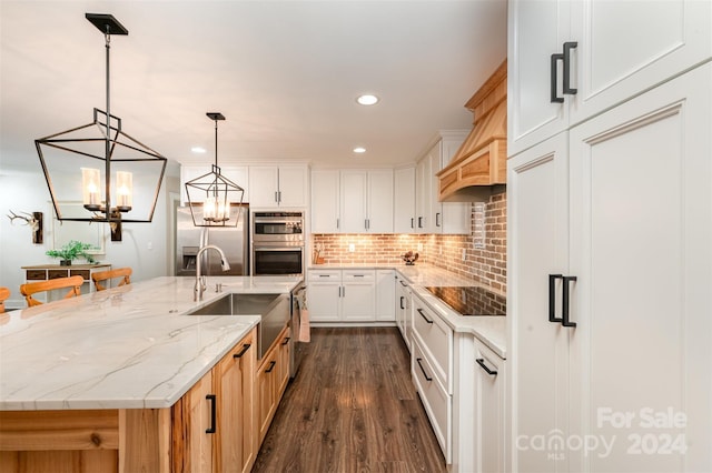 kitchen featuring sink, appliances with stainless steel finishes, a large island, dark hardwood / wood-style flooring, and white cabinetry