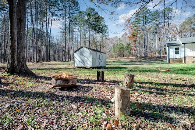 view of yard featuring a fire pit and a storage unit