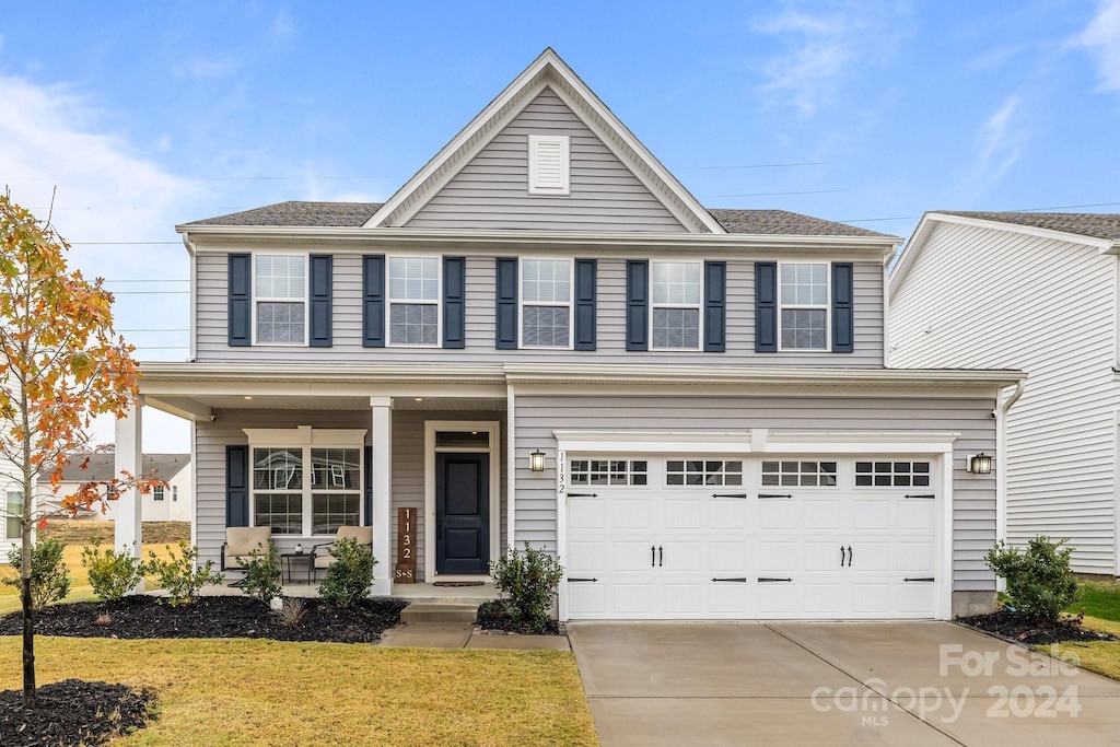 view of property with a front yard and a garage