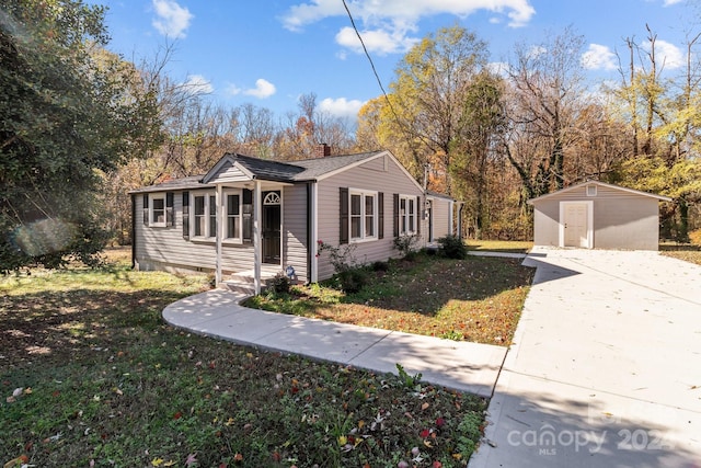 view of front facade featuring a front yard and a storage shed