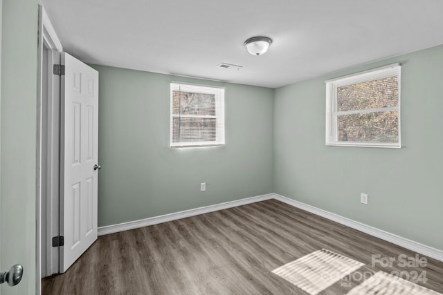 empty room featuring a healthy amount of sunlight and wood-type flooring