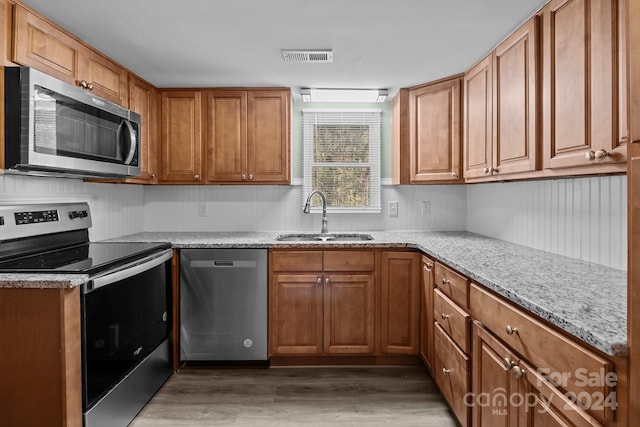 kitchen featuring light stone countertops, sink, dark hardwood / wood-style floors, and appliances with stainless steel finishes