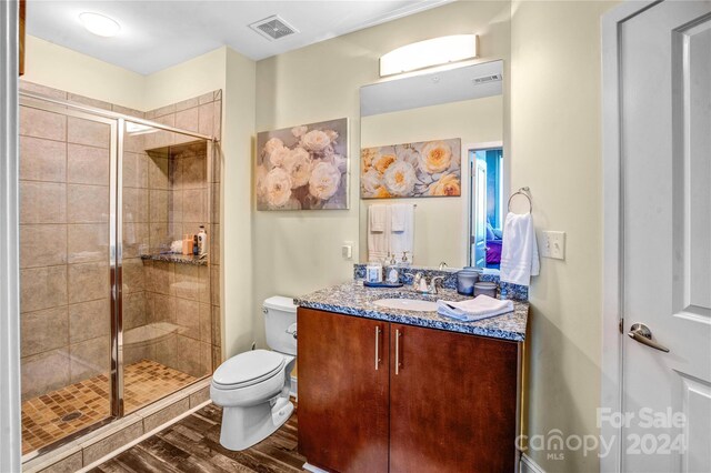 bathroom with walk in shower, toilet, vanity, and hardwood / wood-style flooring