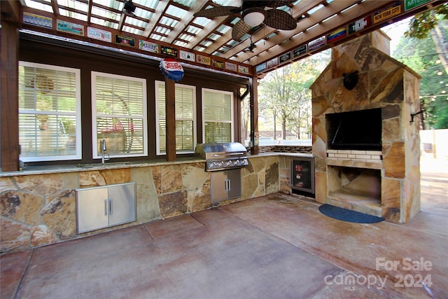 view of patio / terrace with an outdoor kitchen, ceiling fan, sink, grilling area, and wine cooler