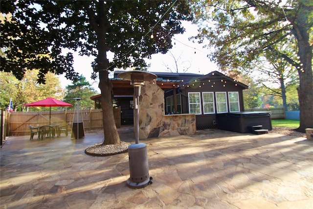 back of house with a patio and a hot tub