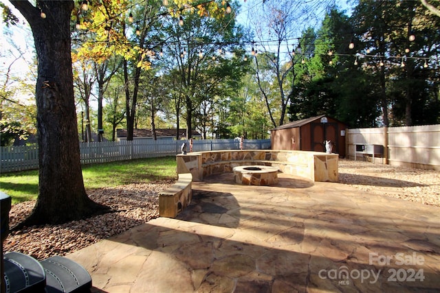 view of patio with a storage unit and an outdoor fire pit