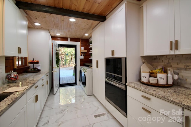 kitchen featuring light stone countertops, white cabinetry, washer and dryer, and appliances with stainless steel finishes