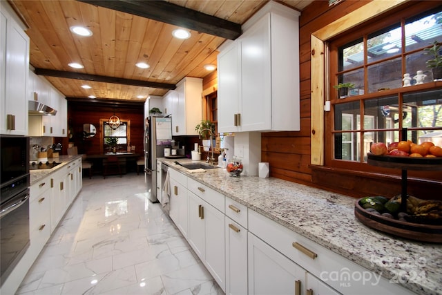 kitchen with white cabinetry, sink, light stone countertops, beamed ceiling, and wood ceiling