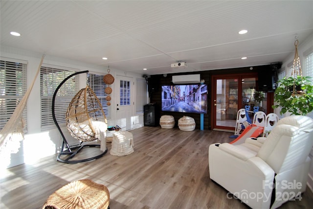 living room featuring a wall mounted air conditioner and wood-type flooring