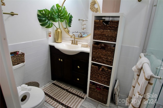 bathroom featuring tile patterned flooring, vanity, tile walls, and toilet