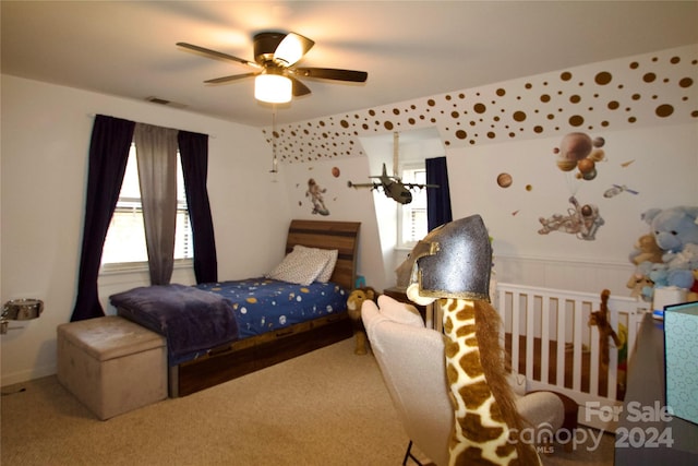 carpeted bedroom featuring multiple windows and ceiling fan