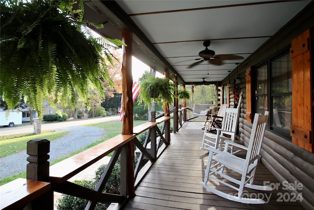 wooden terrace featuring covered porch and ceiling fan