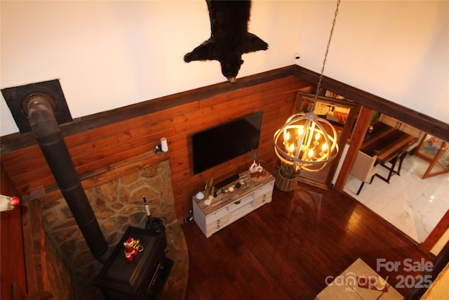 13538 Pine Harbor Rd, Charlotte, NC 28278 - living area with a wood stove, a chandelier, wood finished floors, and wooden walls