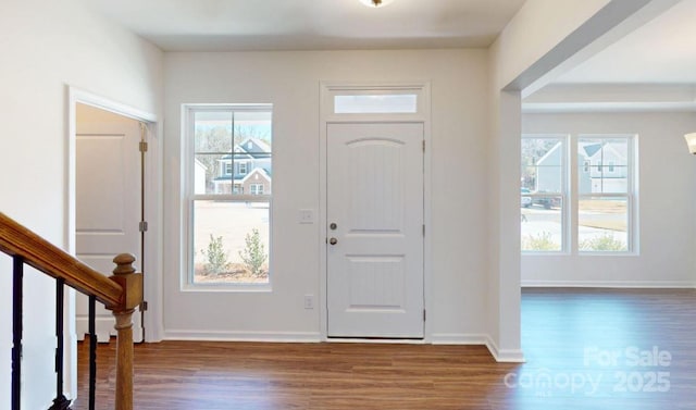 entrance foyer featuring baseboards, stairway, and wood finished floors