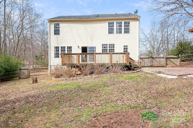 rear view of house featuring a wooden deck