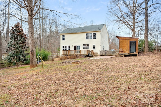 back of house with a deck and a shed