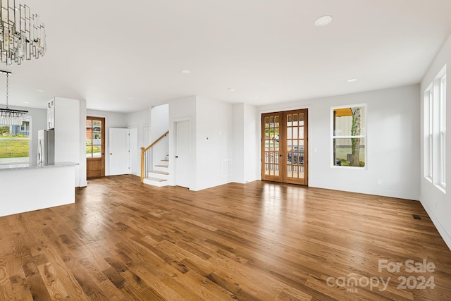 unfurnished living room with french doors, hardwood / wood-style flooring, and plenty of natural light