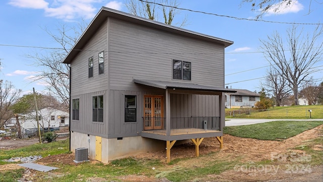 rear view of house featuring a yard and cooling unit