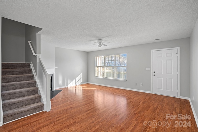 unfurnished living room featuring hardwood / wood-style floors, a textured ceiling, and ceiling fan